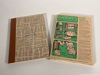 Closed Eaton's textured beige carrying bag with logo centered. Photo taken to show included carrying container.