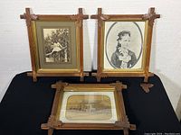 Three antique framed photographs on black surface, showing frames and subject matter