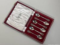 Six sterling silver espresso spoons arranged in original red velvet-lined case with satin interior lid.