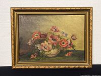 Full view of framed oil painting of flowers in decorative gold-tone frame