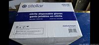 Box showing brand Stellar, 100 gloves per box, medium size, blue powder free nitrile gloves, 10 boxes per case.