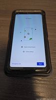 Google Pixel 2XL phone powered on displaying setup screen within OtterBox case on flat surface.