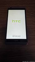 Front view of HTC phone showing boot screen with HTC and Android logo