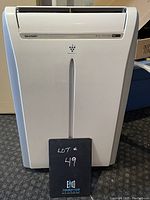 Front view of white Sharp portable air conditioner on wheels, showing the unit's size and design.