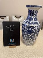 Porcelain vase with blue and white dragon design, sized about 18.5 inches high, shown on white surface next to a black board.