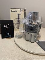 Breville Juice Fountain Compact juicer with original box, manual, and accessories on a light surface.