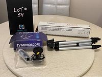 Both the camera tripod and TV microscope shown on table, with packaging and items visible.