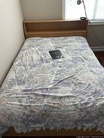 Full view of the captain's bed with floral bedspread, showing bed frame and detached headboard with integrated shelf.