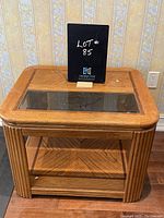 Front view of vintage wooden coffee table showing glass insert, bevelled legs, and lower shelf.