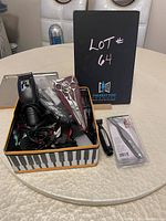 Metal container with a ConAir electric hair clipper, clipper guard attachments, scissors, comb, and a packaged trimmer.