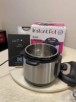 Instant Pot Duo 6 Quart pressure cooker with lid, inside stainless steel cooking pot, and original box visible.