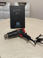 Side view of the Jobmate heat tool on a table showing power cord and nozzle