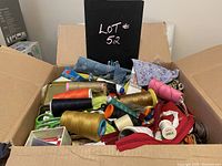Box filled with various sewing items including multiple spools of thread, fabric pieces, sewing needles, pins, scissors and trims.