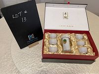 Boxed sake tea set with six ceramic cups and a glass bottle in a satin-lined gift box