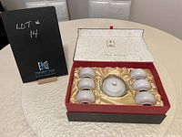 Photo showing the full set inside the gift box with lid open, containing one teapot and six cups on a satin lined tray.