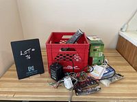Photo showing the red crate and additional items outside the crate including electrical or electronic components and chargers.