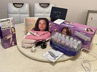 Complete vintage hair styling lot including curlers, foldable hair dryer and ThermaCap box on table
