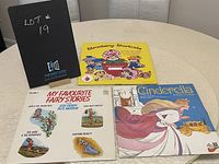 Photo showing all three children's vinyl LP covers arranged on a table: Cinderella, Fairy Tale Stories, and Strawberry Shortcake.