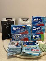 Photo of unopened Ziploc boxes, vacuum pack bags, and gloves arranged on a table.