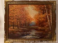 Framed autumn landscape painting on board 19" x 23" with orange and brown foliage and a stream.