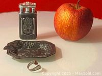 Vintage metal lighter with 'Choppers' cross emblem beside an apple and ashtray