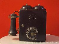 Front view of the Northern wall telephone showing rotary dial, handset holder, and twin metal bells on top.