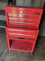 Front view of red Jobmate two-piece tool chest showing the multiple drawers and wheels