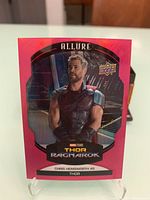 Front of 2022 Marvel Allure Thor Ragnarok Pink trading card showing Thor image with movie title and actor's name.
