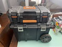 Photo of two stacked tool boxes, Ridgid on top and Husky below with wheel visible.