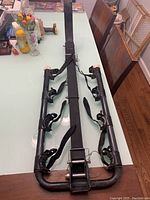 Full view of Allen bicycle rack laid flat on table, showing metal frame and securing straps.