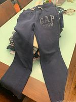 Navy blue GAP sweatpants with drawstring waistband, size XL kids, folded on a table.