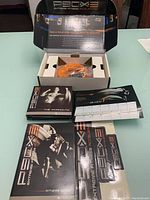 Open box showing DVDs, resistance band, and guides laid out.