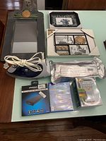 Full view of all items on the table showing the mirror, photo frames, electric iron, power bank, DVD, and baking cups.