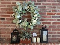 Full lot display against brick wall showing wreath, lanterns, candles, and decorative box
