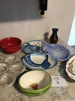 Overview of fish themed serving dishes including sectioned fish tray, oyster plate, watermelon bowl, shell dish, and small brown vase