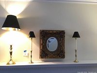 Full view of the electric candlestick lamp, two matching candlesticks, and the gold framed mirror on a mantel