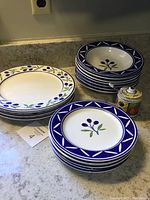 Dinner plates, salad plates, soup bowls stacked with sugar bowl visible