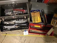 Two open Craftsman metal toolboxes showing their contents including wrenches and woodworking tools laid out around them.