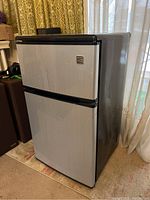 Full front and side angled view of Kenmore bar fridge, closed doors, showing two-door design with freezer on top and fridge below