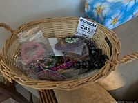 Basket containing multiple costume jewelry bracelets, some in plastic packaging, arranged loosely.