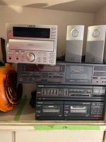 Front view of the stacked audio equipment showing TEAC CD unit, Yamaha speakers, JVC cassette deck, Toshiba amplifier with cassette and EQ.