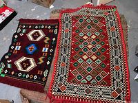 Both Kilim rugs shown side by side on a woven mat on a concrete floor.