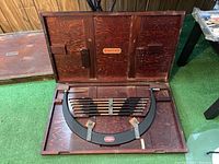 Open wooden case showing micrometer frame and extension rods arrayed inside