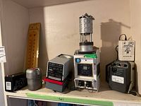 Full view of mining equipment shelf including Koehler oil lantern, Durst M 600 photographic enlarger with Schneider-Kreuznach lens, Status Engineering rechargeable battery unit, and analog meters.