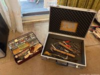 Aluminum tool case with foam on lid, containing hammers, drill bits, pliers, and other assorted hand tools.