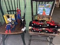 Die-cast model trucks displayed in original packaging including Ford 1929 and Chevrolet 1952 models, and a packaged water gun on a chair.