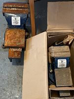 Overview of two swivel base bench vises side by side, one new in box 3 inch and one used 5 inch rusty.