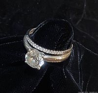 Solitaire ring and matching enhancer stacked on black velvet background