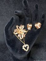 All four pieces displayed on black background with hand model