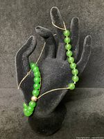 Necklace and bracelet displayed on black hand stand